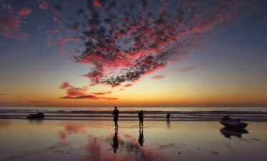 two person standing on shore